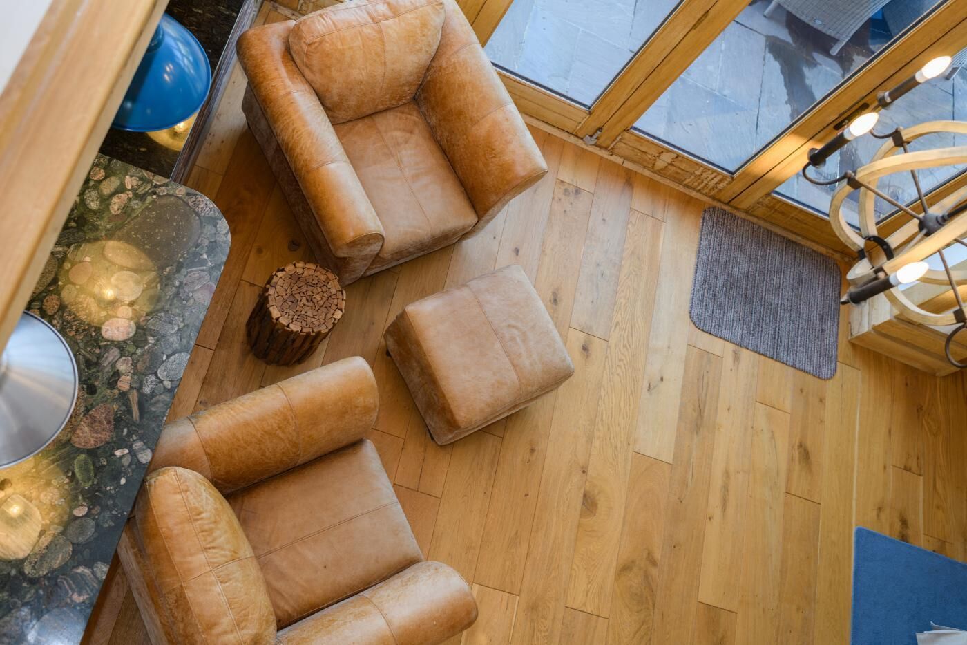 Ein Raum mit hohen Decken, Holzboden, Glasdecke und einem modernen Kronleuchter.
