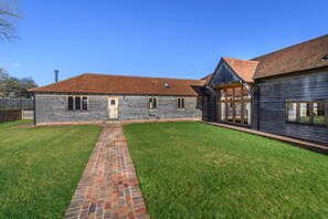 A two-story building with a brick pathway leading to the entrance.