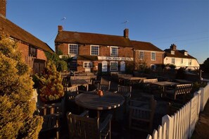 Un pub traditionnel doté d’une terrasse et d’une enseigne indiquant : « The Merry Inn ».