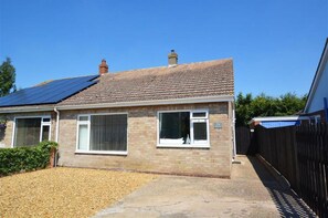A two-story house with a tiled roof, solar panels, and a brick exterior. - 2 Bed in Wells-next-the-Sea (oc-1655) (Wells-next-the-Sea)