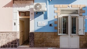 A building facade with a stone base, a blue upper section, a sign reading 'Polo Marina,' and a white door with shutters. - Perla Marina Ground Floor Apartment with Wi-Fi and Air Conditioning (Trappeto)