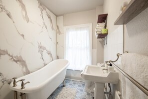 A bathroom with a freestanding bathtub, a pedestal sink, and a towel rack. - 2 Bed in Cromer (oc-s32971) (Cromer)