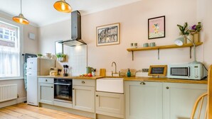 A compact kitchen with a built-in oven, a microwave, and a sink. There are wooden cabinets and a wooden countertop. - 2 Bed in Cromer (oc-s32971) (Cromer)