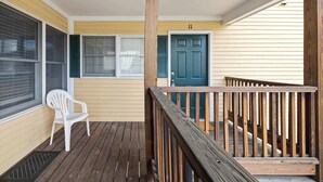 A wooden deck with a white plastic chair, a blue door, and a wooden railing. - Bright 2BR Escape 2 Min to Okemo, Walk to Downtown (Ludlow)