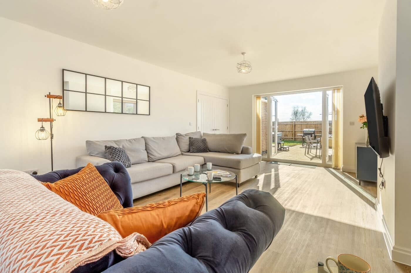 A modern living room with a sofa, coffee table, and a TV mounted on the wall.
