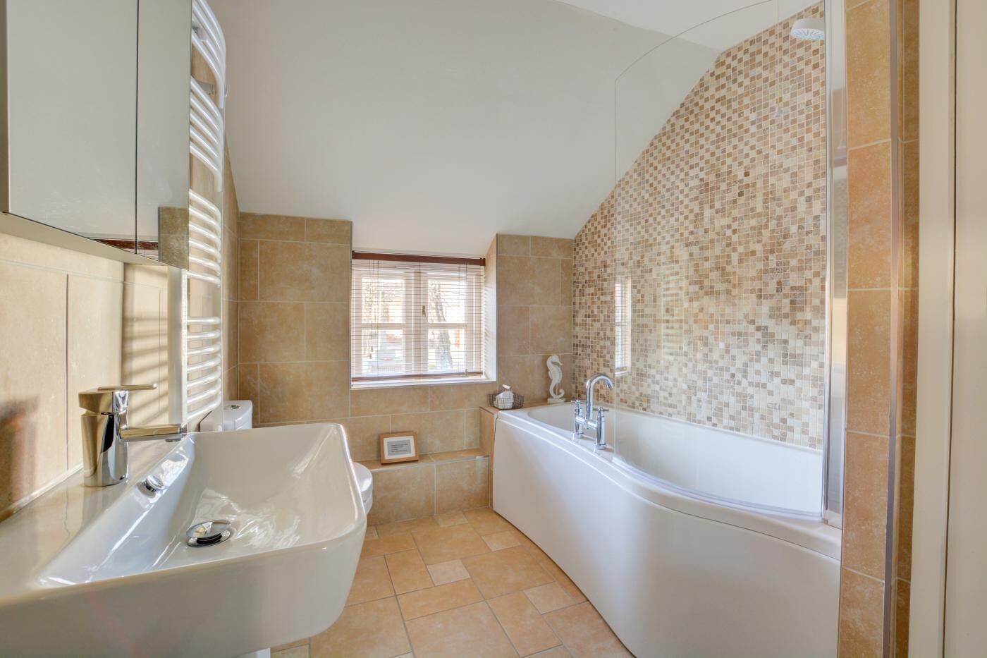 A modern bathroom with a freestanding bathtub, a sink, and a large mirror.