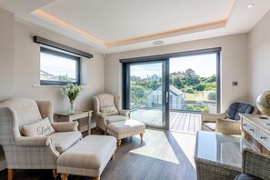 A spacious living room with a balcony, furnished with a sofa, armchairs, and a coffee table. - 5 Bed in Walmer (oc-do022) (Kingsdown)