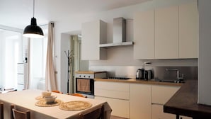 A modern kitchen with white cabinets, a built-in oven, and a coffee maker. - House in the center Bergamo (Bergamo)