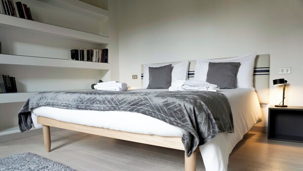 A modern bedroom with a bed, bedside tables, a bookshelf, and a rug. - House in the center Bergamo (Bergamo)