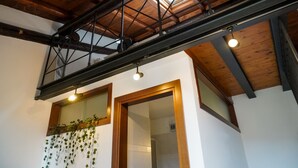 A room with a high ceiling, wooden beams, a skylight, and a hanging plant. - House in the center Bergamo (Bergamo)
