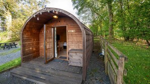Une cabane en bois avec un toit incurvé, une porte et une enseigne indiquant qu’il s’agit d’une chambre « Super Deluxe ».