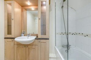 A bathroom with a wooden vanity, a sink, a mirror, and a shower area. - 2 Bed in Sidmouth (oc-t32948) (Sidmouth)