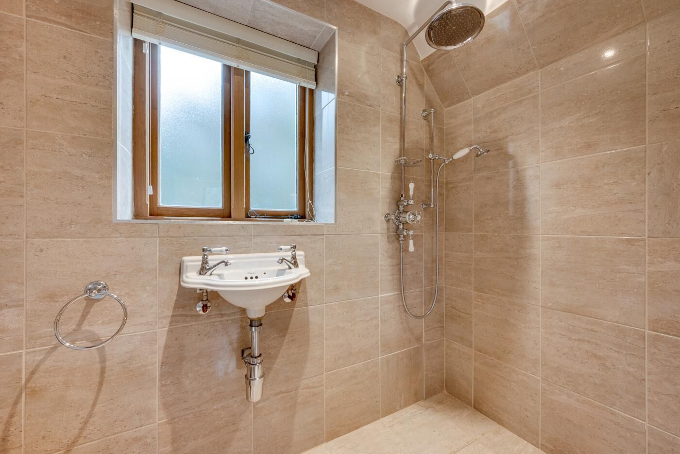 A bathroom with a sink, window, and shower.