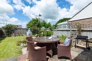 A patio with wicker furniture, a round table, and a grill. - 2 Bed in Winchelsea (oc-rh1143) (Winchelsea Beach)