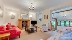 A living room with a fireplace, a TV, and a staircase leading to another level. - 3 Bed in Hartfield (oc-tw653) (Hartfield)