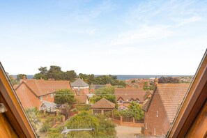 Ein Wohngebiet mit Häusern, blauem Himmel und Blick auf das Meer.