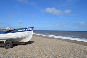 Ein Boot namens 'ANNA GAIL' mit dem Kennzeichen 'YH2413' an einem Kiesstrand.