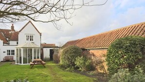 Une maison traditionnelle dotée d’une véranda, d’un jardin et d’une extension en briques.