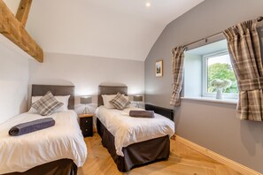 A bedroom with two beds, a window with curtains, a radiator, and a wooden ceiling beam. - 2 Bed in Summerbridge (oc-o32940) (Hartwith cum Winsley)