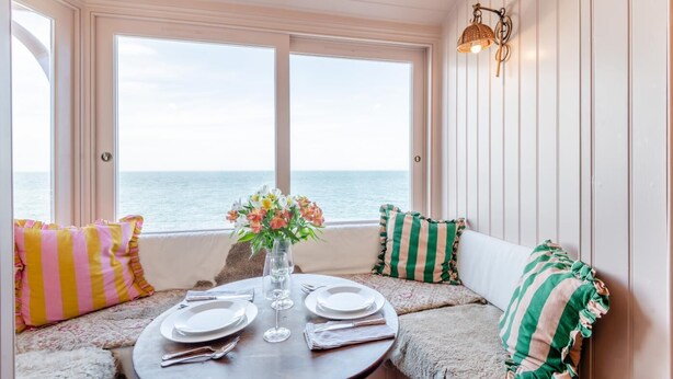 Ein Essbereich mit Tisch für zwei Personen, mit Blick auf das Meer.