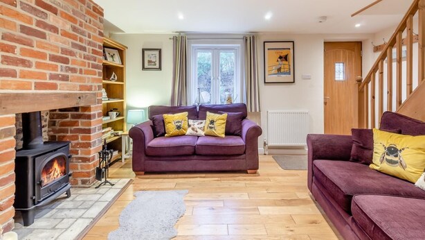 A cozy living room with a brick fireplace, two sofas, and a bookshelf. - 3 Bed in Middleton (oc-fdp) (Middleton Moor)
