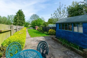 A backyard with a lawn, a wooden fence, a blue shed, and a garden table. - 3 Bed in Middleton (oc-fdp) (Middleton Moor)