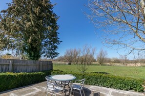 A patio with a round table and chairs, surrounded by a hedge and a wooden fence. - 3 Bed in Middleton (oc-fdp) (Middleton Moor)