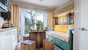 Eine moderne Küche mit Essbereich, einer Couch und Blick ins Freie.