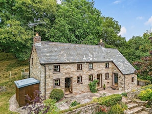 A stone house with a sloped roof, multiple windows, and a small shed. - 2 Bed in Llandefalle (oc-n32991) (Llandefalle)