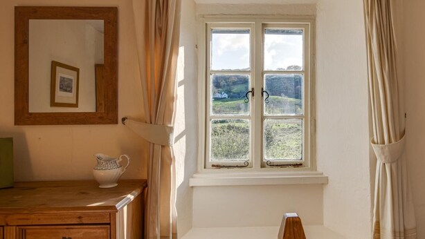 A room with a window, a wooden dresser, a white pitcher, and a mirror on the wall. - 3 Bed in Little Langdale (oc-gl102) (Little Langdale)