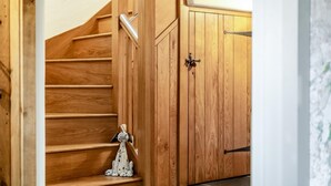 A wooden staircase leading to a room with a cabinet and a small figurine on the landing. - 3 Bed in Outgate (oc-gl018) (Outgate)