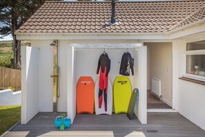 A covered outdoor area with surfboards and wetsuits. - 4 Bed in Woolacombe (oc-w33003) (Woolacombe)