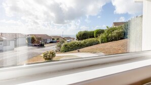 Quartiere residenziale con case, una strada e vista sul mare.