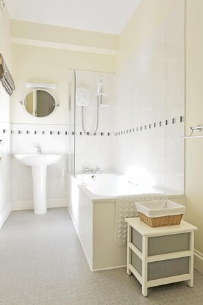 Un baño con lavamanos, bañera y ducha.