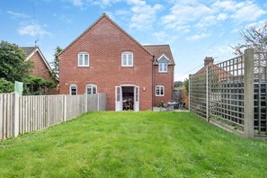 A red brick house with a fenced backyard and a wooden fence. - 3 Bed in Little Walsingham (oc-1229) (Little Walsingham)