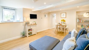 A modern living room with a flat-screen TV, a dining table with chairs, a sofa, and a bookshelf. - 1 Bed in Crook (oc-gl077) (Crook)