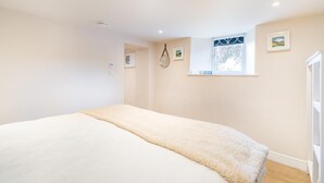 A bedroom with a large bed, a window with a view, and a door to the right. - 1 Bed in Crook (oc-gl077) (Crook)