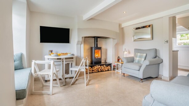 A modern living room with a fireplace, a flat-screen TV, and a sofa.