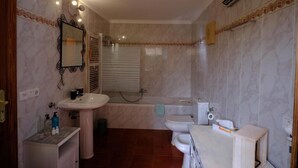 A bathroom with a sink, toilet, bathtub, and a mirror. - Agroturismo S'Hort de Can Carrio (Ses Salines)