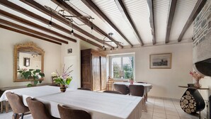 A dining area with a long table, chairs, a mirror, and a fireplace. - “Chambre Champêtre” Guest Room with Shared Terrace, Garden, and Wi-Fi (Mont-Dol)