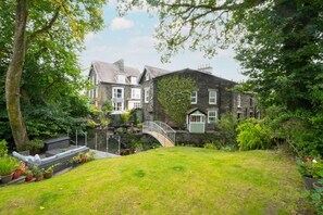 A stone house with a small bridge leading to a garden. - 4 Bed in Windermere (oc-gl130) (Windermere)