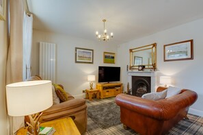 A living room with a television, fireplace, and a large mirror. - 4 Bed in Windermere (oc-gl130) (Windermere)
