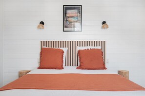A bed with a striped headboard, two pillows, and a blanket.