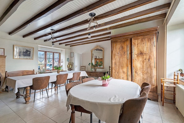 Un comedor con una mesa larga, sillas y una puerta de madera.