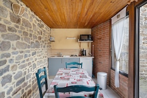 Una cocina compacta con microondas, lavabo y una ventana pequeña.