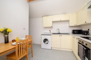 A compact kitchen with a washing machine, a sink, and a microwave. - 1 Bed in Wellesbourne (oc-w33028) (Wellesbourne)