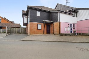 A two-story residential building with a brick facade, a dark-colored upper section, and a pink lower section. - 2 Bed in Horning (oc-h33013) (Horning)