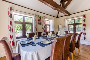 A dining room with a table set for four, wooden chairs, and large windows with curtains. - 5 Bed in Clows Top (oc-m32976) (Clows Top)