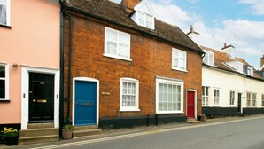 A row of terraced houses with distinct door colors and a clear road in front. - 2 Bed in Woodbridge (oc-csn2) (Woodbridge)