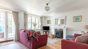 A living room with a sofa, a television, a fireplace, and a window with curtains. - 2 Bed in Friston (oc-lcq) (Friston)